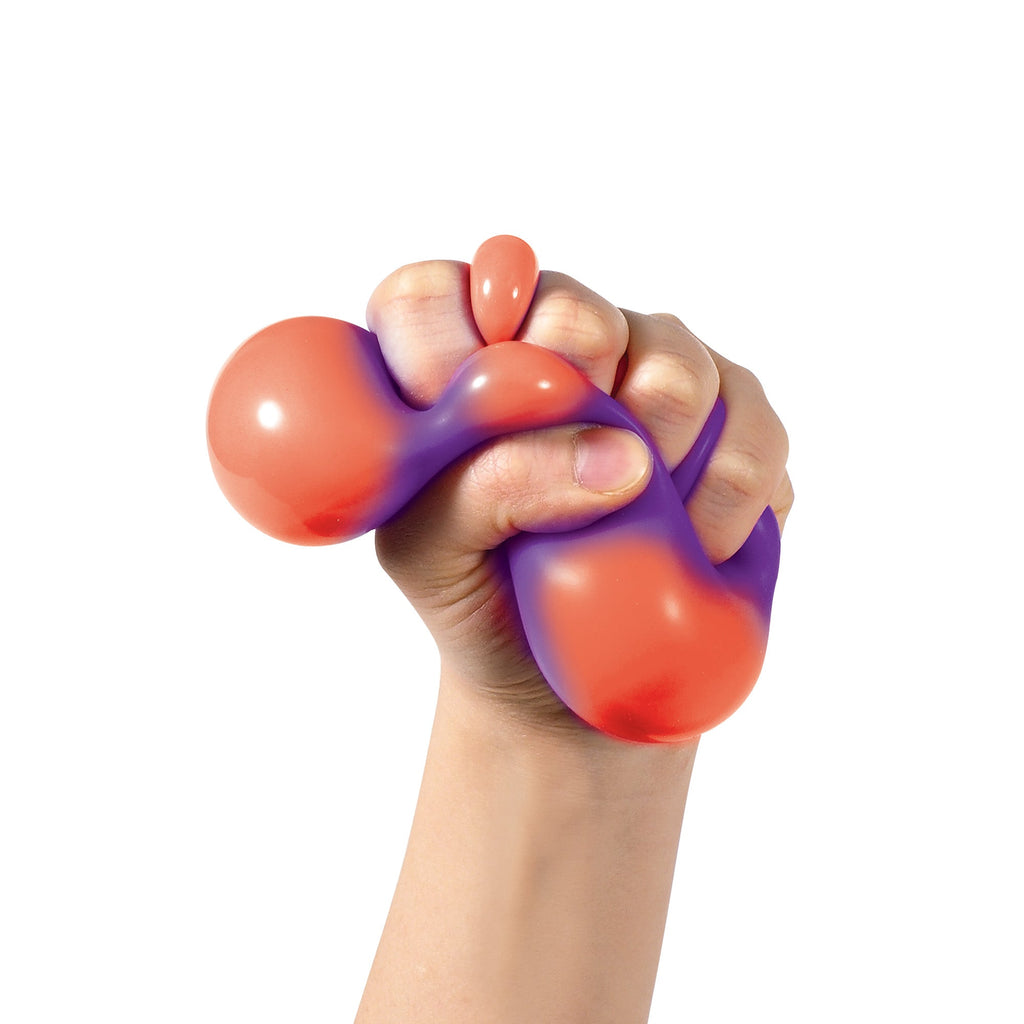 Color Change Squeeze Heart S3 - A hand tightly gripping a squishy, bi-colored sensory toy. The toy is primarily orange with a purple gradient. The background is plain white, highlighting the texture and colors of the sensory toy.